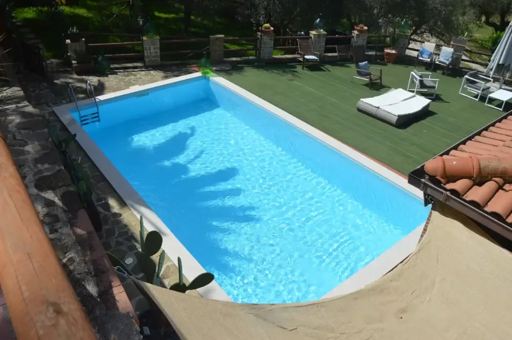 La piscina vista dall'alto, con il prato e i lettini